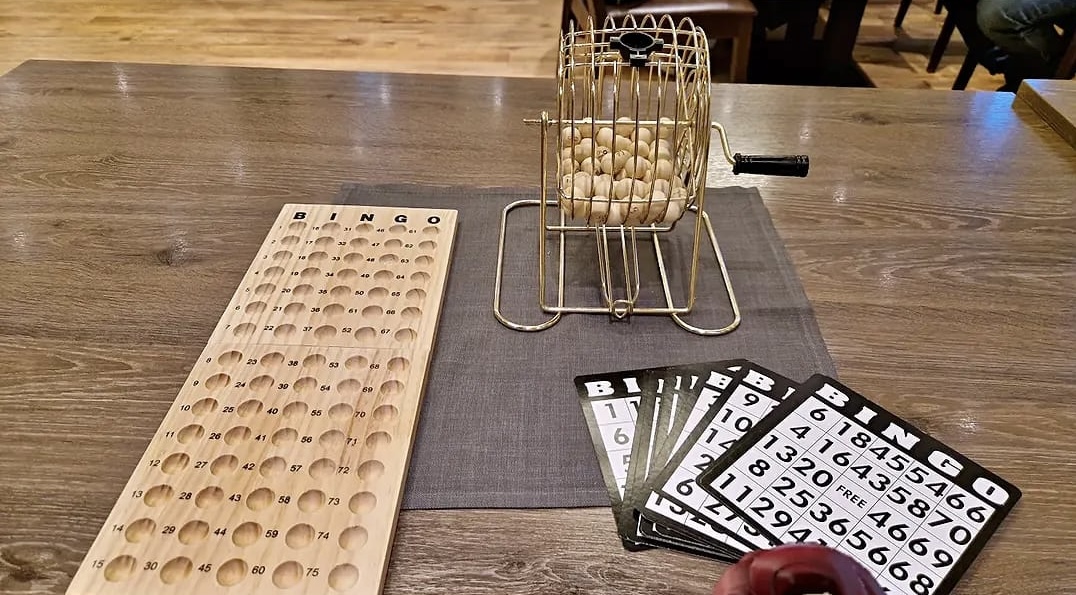 Bingo-Trommel, Zahlenbrett und Bingo-Karten beim Teamevent