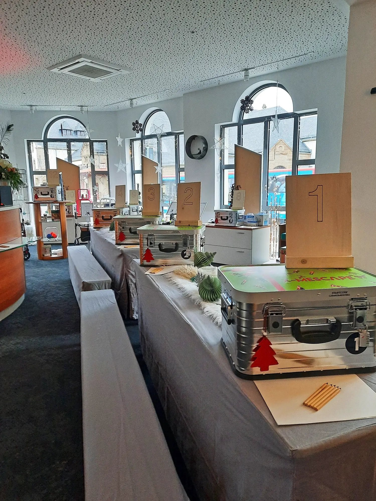 Nummerierte X-MEScape-Koffer aus Aluminium auf weihnachtlich dekorierten Tischen