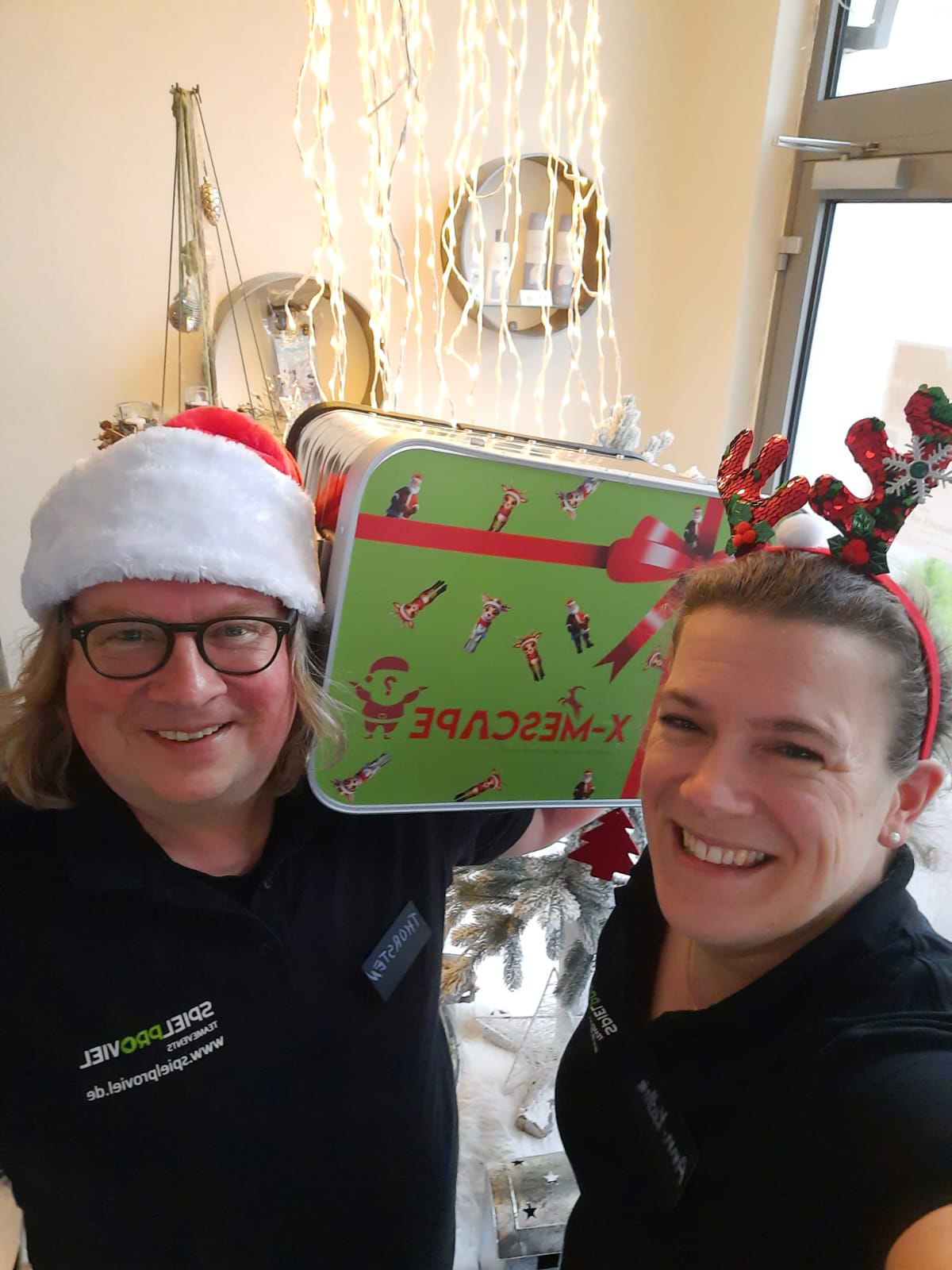 Ann-Kathrin und Thorsten von Spielproviel mit Weihnachtsmütze, Rentiergeweih und dem X-MEScape-Koffer